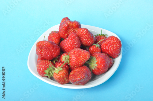 Strawberries on a plate on a blue background