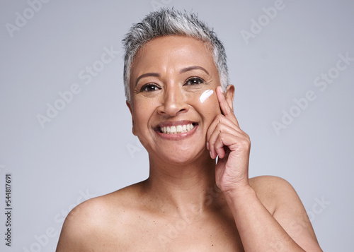 Skincare, cream and senior woman in studio portrait for beauty, healthy glow and cosmetics with mock up for advertising, promotion and marketing. Happy old woman with sunscreen or antiaging product