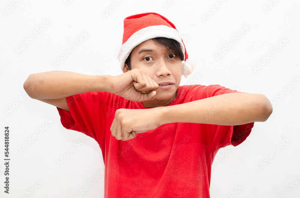 expressive happy young asian man in christmas santa theme clothes wit shocked, surprised and amazed face expression. wow expression man in red santa hat. christmas model concept for sale and discount. expressive happy young asian man in christmas santa theme clothes wit shocked, surprised and amazed face expression. wow expression man in red santa hat. christmas model concept for sale and discount.