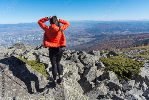 Woman standing on a rocks high  in the autumn  mountain above the city of Sofia. Vitosha mountain,  ,Bulgaria