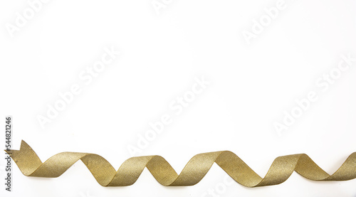 Gold ribbon isolated on white background, shiny curly christmas decoration,