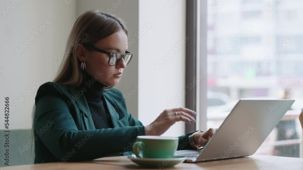 attractive businesswoman is typing message on laptop keyboard in cafe, sending emails to partners attractive businesswoman is typing message on laptop keyboard in cafe, sending emails to partners