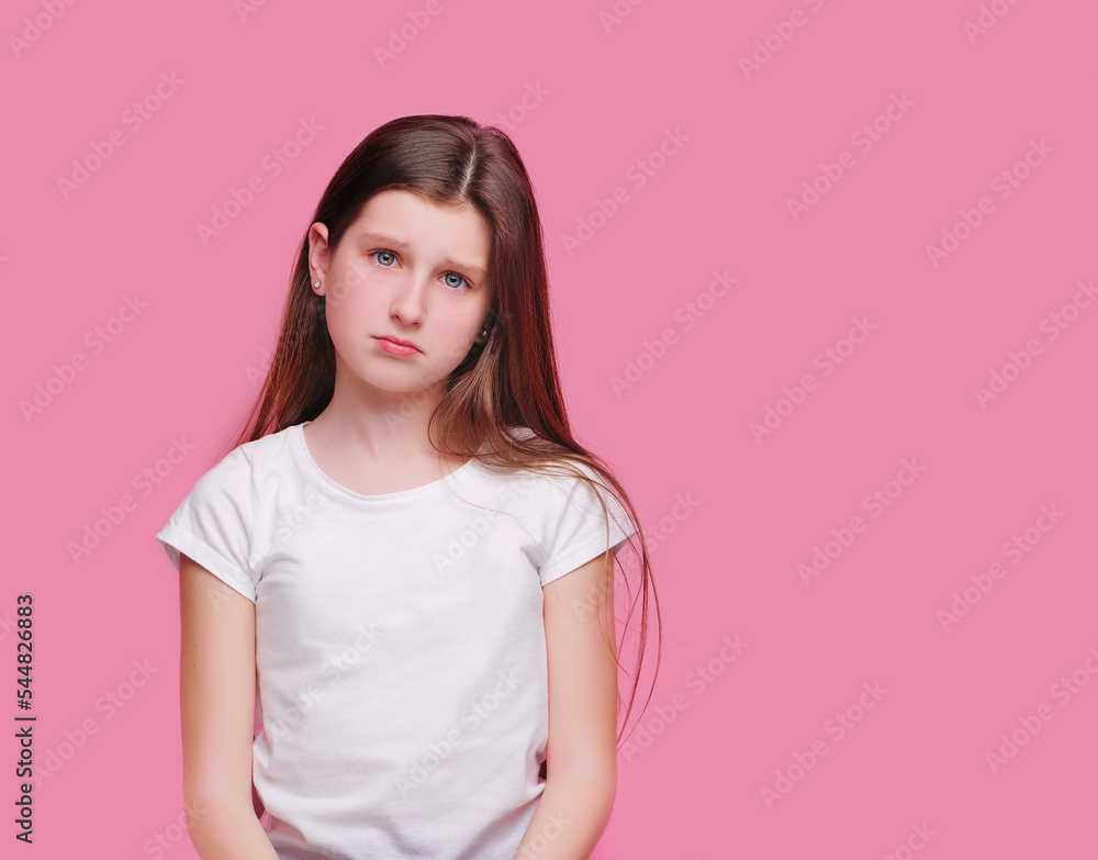 Sad brunette teen girl against pink background Sad brunette teen girl against pink background
