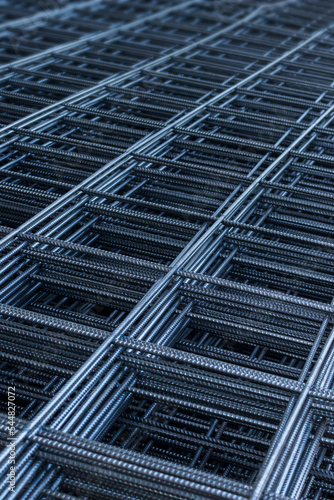 Vertical image group of gloss surface deformed bar or reinforced concrete construction steel net piles on outdoor ground. Selective focus and blurred for copy space.