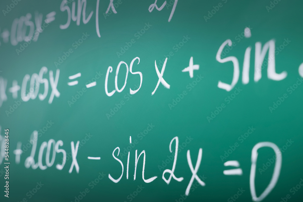 Many different math formulas written on green chalkboard, closeup Many different math formulas written on green chalkboard, closeup