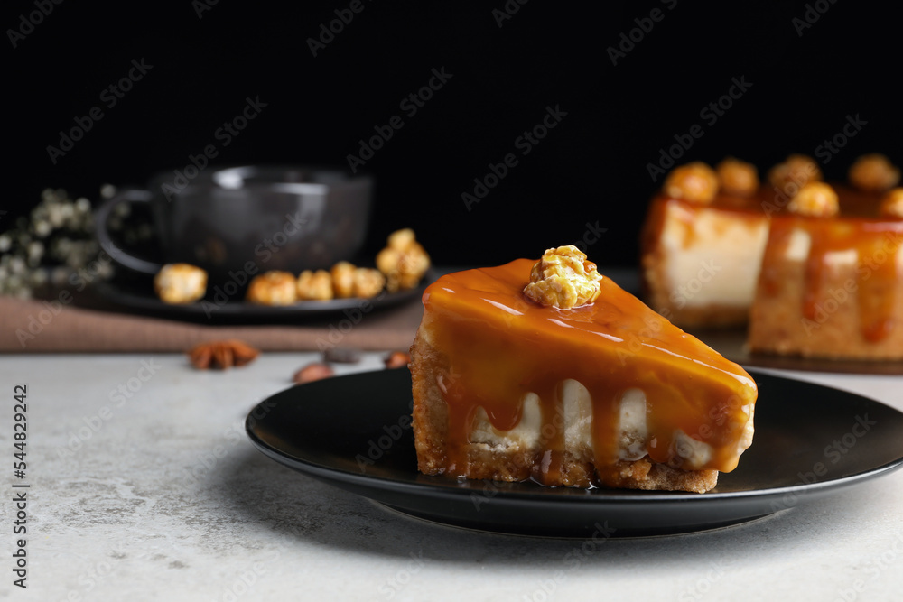 Piece of delicious cake with caramel and popcorn on light grey table, space for text - obrazy, fototapety, plakaty 