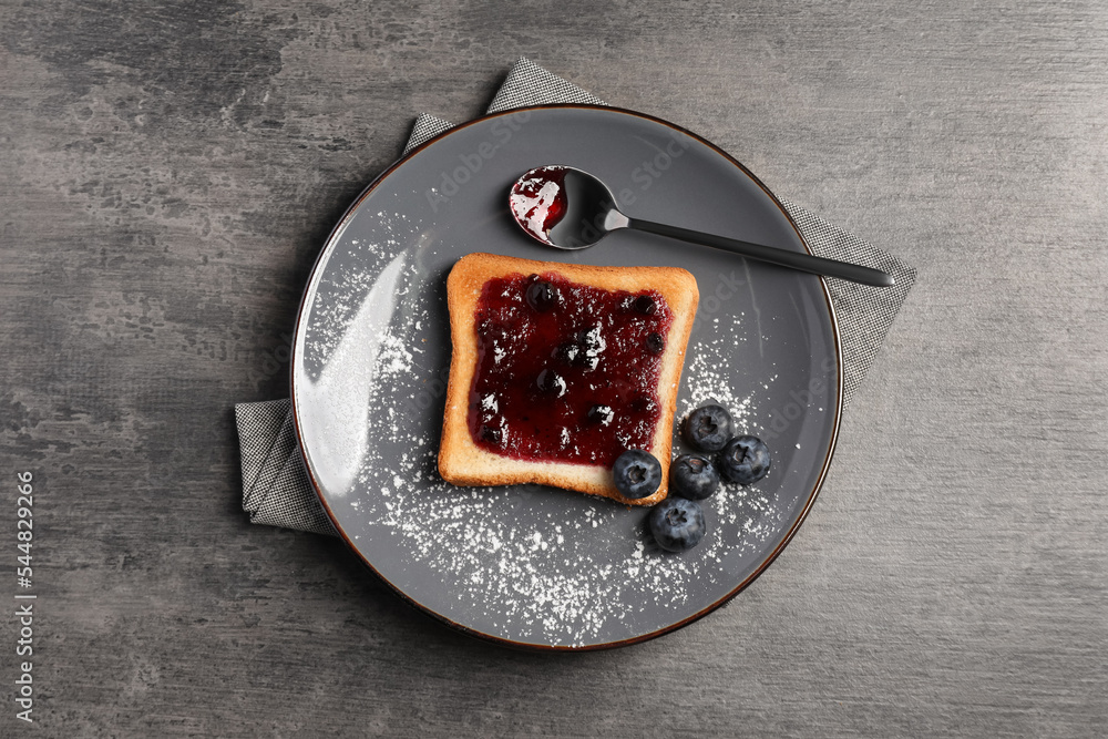 Delicious toast served with jam and blueberries on grey wooden table, top view Delicious toast served with jam and blueberries on grey wooden table, top view