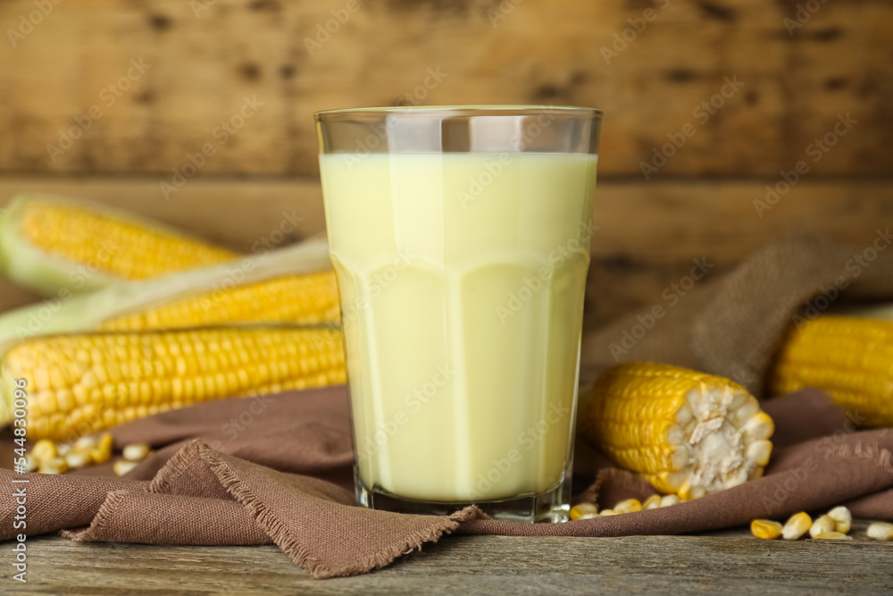 Freshly made corn milk in glass on wooden table Freshly made corn milk in glass on wooden table