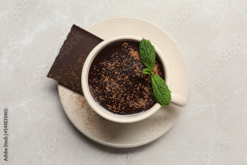 Cup of delicious hot chocolate with fresh mint on grey table, top view
