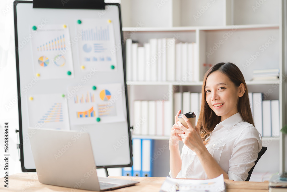 Young asian businesswoman beautiful charming smiling and using on mobile phone in the office Young asian businesswoman beautiful charming smiling and using on mobile phone in the office