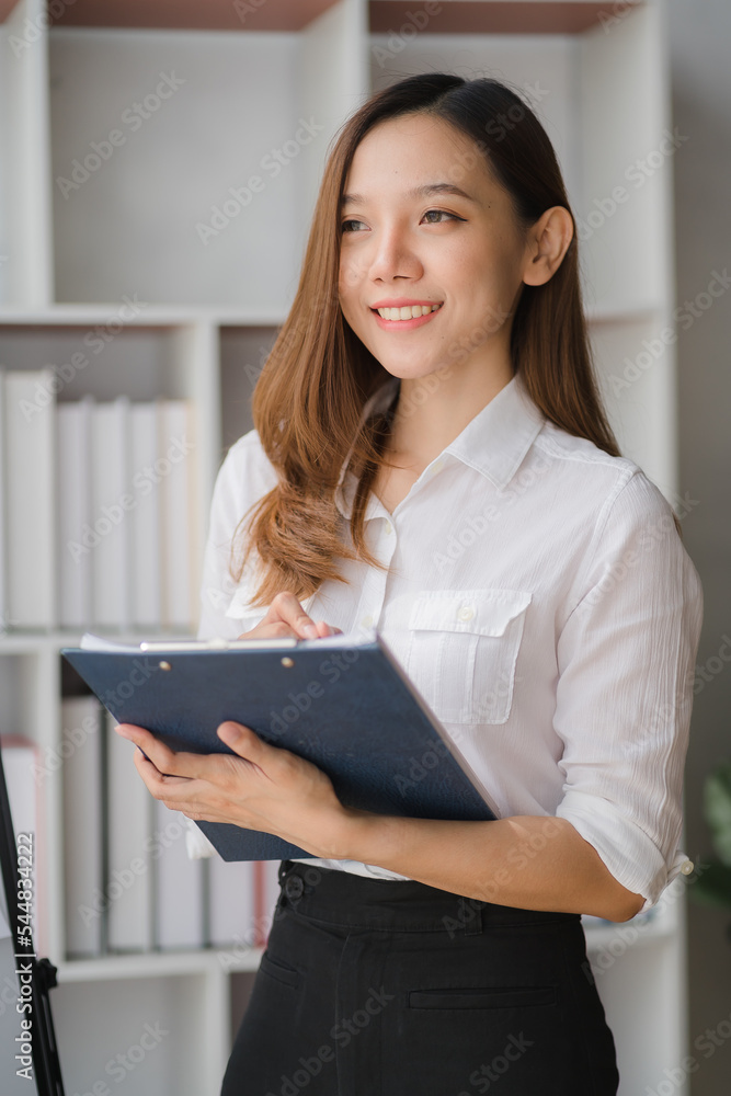Beautiful Asian businesswoman standing confidently preparing for work. Beautiful Asian businesswoman standing confidently preparing for work.