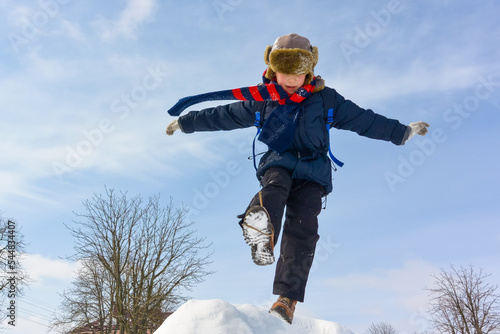 Boy, jumping, having fun on a snowy winter park