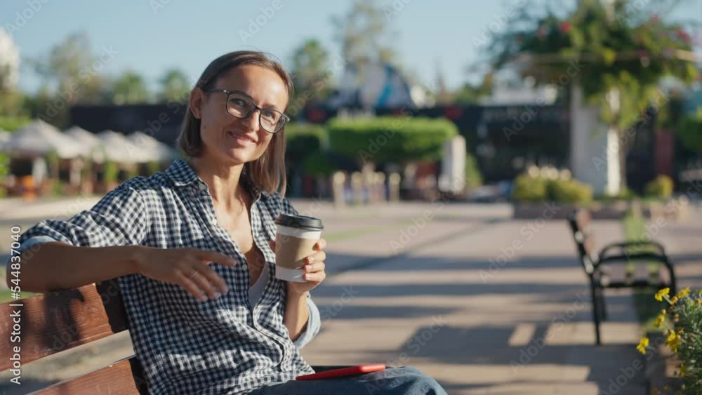 Young woman in park with tablet and takeaway coffee. Young woman in park with tablet and takeaway coffee.