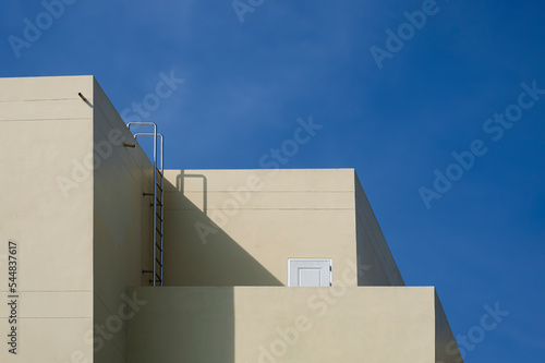 Sunlight and Shadow on yellow wall of Modern office Building against blue sky, Street minimal Architecture Background concept