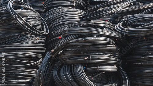Various sizes of the old black Cable lines stacked in a big pile for reuse and recycling