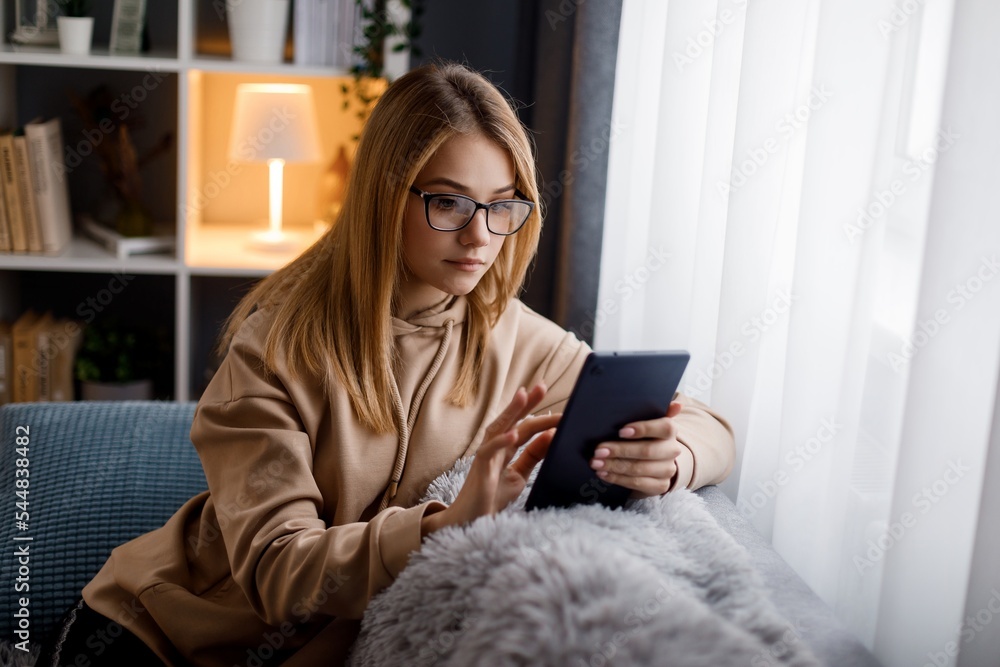Woman using tablet on couch Woman using tablet on couch