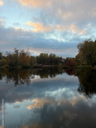 Fototapeta Naklejka Na Ścianę i Meble -  Autumn trees reflection on the pond surface in the park
