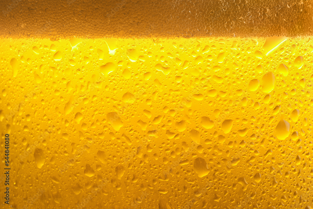 Glass of tasty cold beer with foam and condensation drops as background, closeup Glass of tasty cold beer with foam and condensation drops as background, closeup