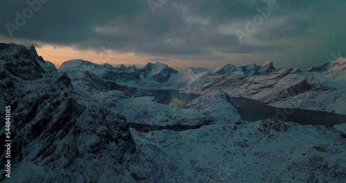 Frozen alien Lofoten Svartvatnet head jagged mountain range terrain aerial view orbiting ghostly cold valley photo