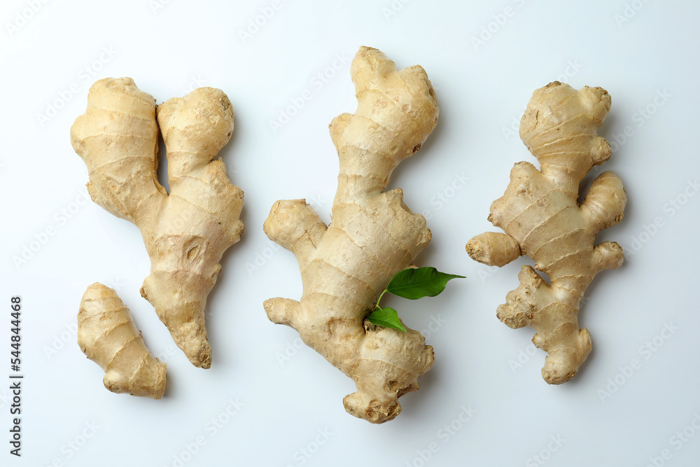 Fresh ginger with green leaves on white background, flat lay Fresh ginger with green leaves on white background, flat lay