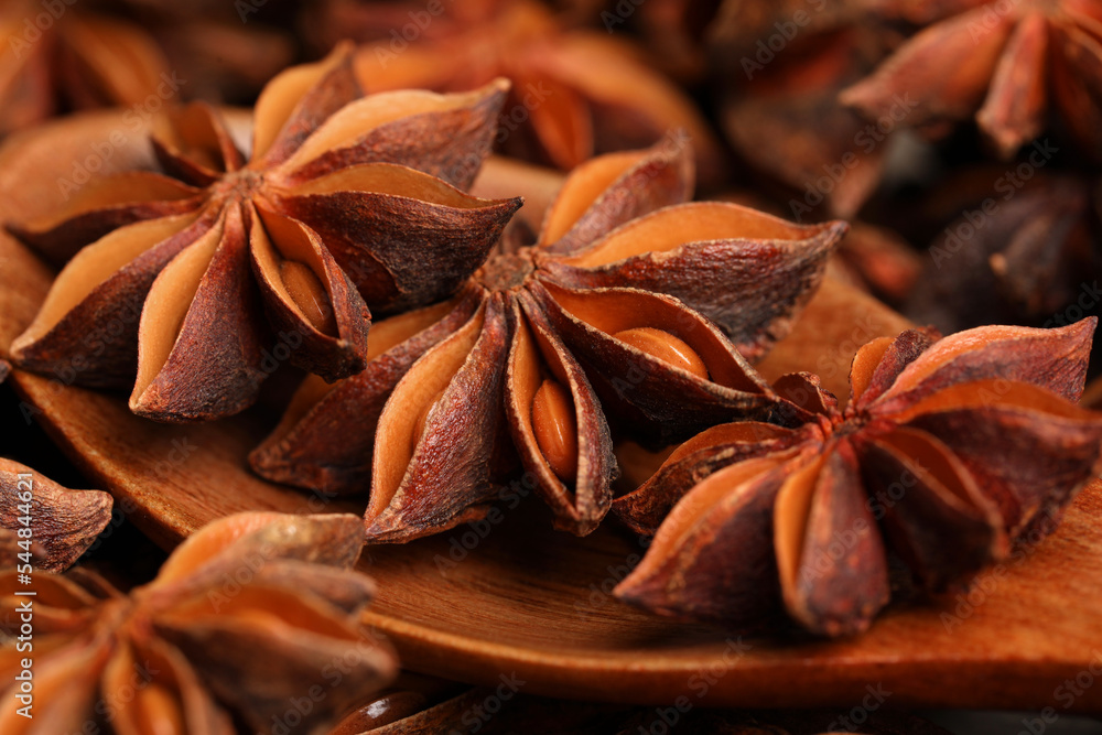 Aromatic anise stars and wooden spoon on table, closeup Aromatic anise stars and wooden spoon on table, closeup