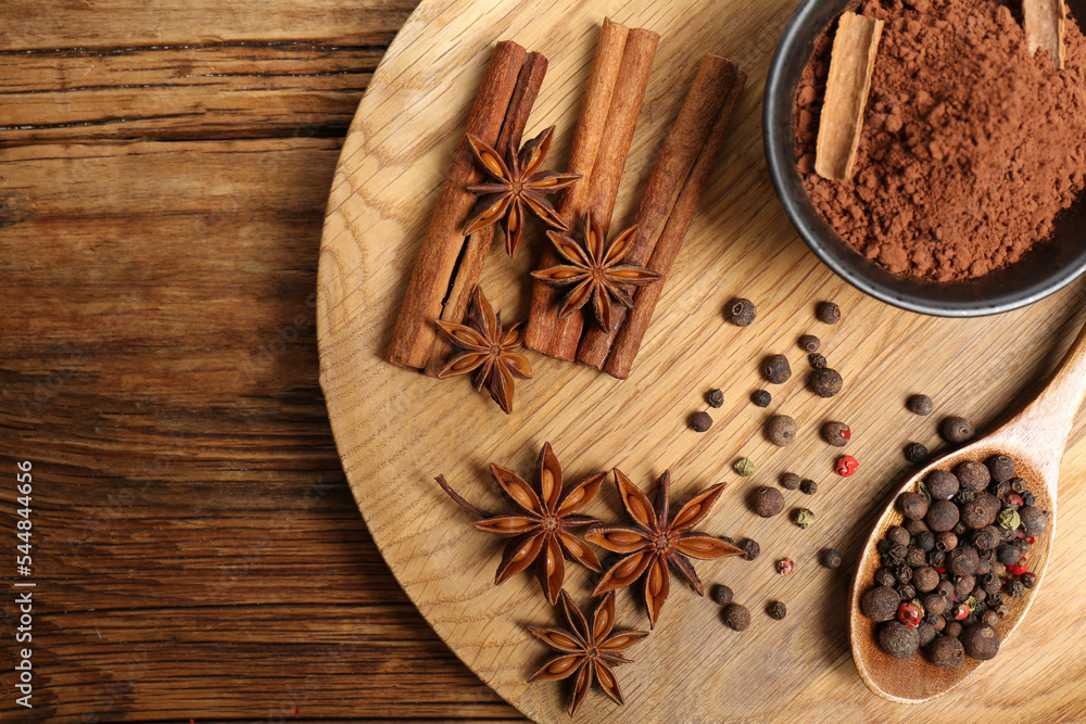 Aromatic anise stars and spices on wooden table, flat lay