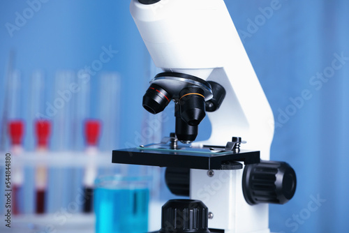 Modern medical microscope with glass slide in laboratory, closeup