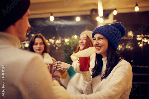 New acquaintances at Christmas holidays and parties. Happy man and girl at romantic dating with hot drinks. Concept of emotions  vacations  love  friendship