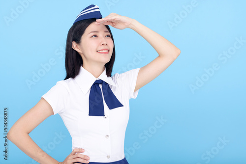 Airplane stewardess young woman looking far away isolated on blue background