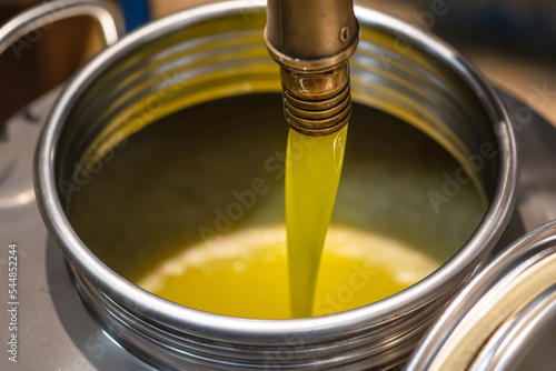 Canvastavla Fresh extra virgin olive oil pouring into tank at a cold-press factory after the