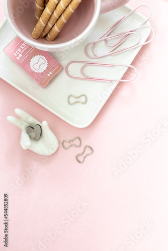 Desktop flat lay of office stationery items with copy space on a pink desktop