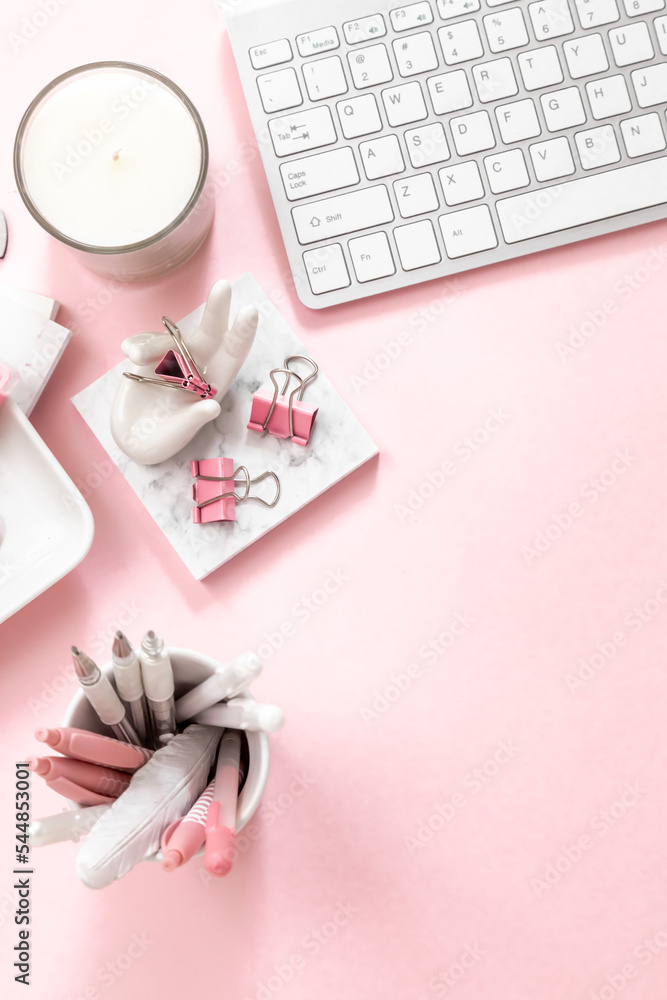 A feminine workspace, keyboard of a computer on pink background with copy space A feminine workspace, keyboard of a computer on pink background with copy space