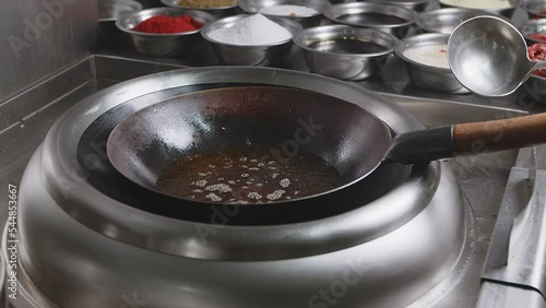 Oil boils in a large wok pan.