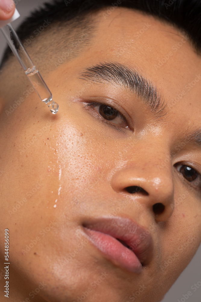 Close-up of person applying serum on face