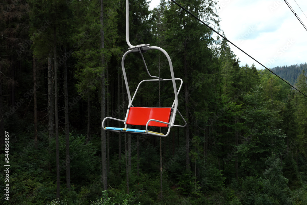 Empty ski lift and green trees at mountain resort Empty ski lift and green trees at mountain resort