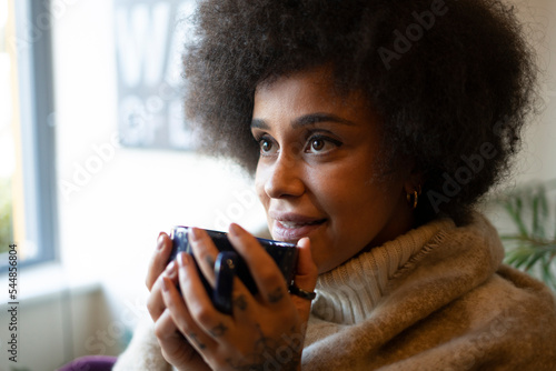 Smiling woman holding mug with hot drink