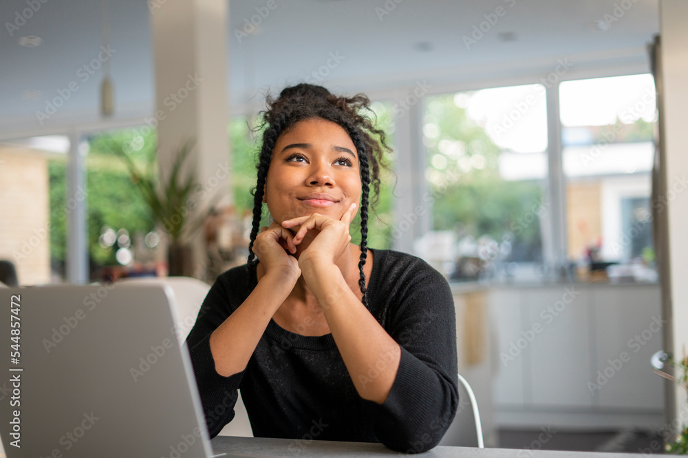 Teenage girl using laptop and thinking Teenage girl using laptop and thinking