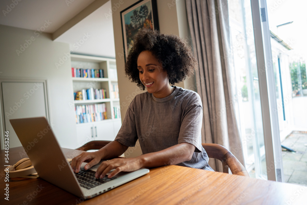 Smiling woman using laptop at home Smiling woman using laptop at home
