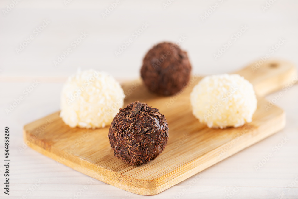 Sweets truffles with chocolate and coconut on a board, traditional brazilian sweets. Sweets truffles with chocolate and coconut on a board, traditional brazilian sweets.