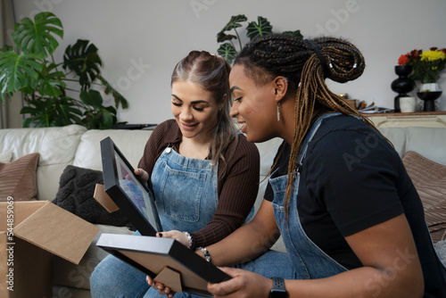 Two young women unpacking boxes in new home