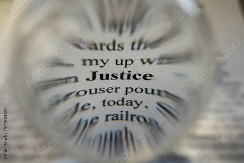 The word Justice has been focussed in on and singled out using selective focus and Bokeh to blur out the surrounding words drawing the viewers eye to the one specific word that is the subject  photo