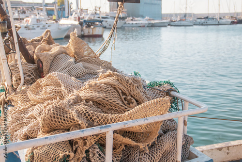 Redes y aparejos de pesca en Monopoli, Puglia, Italia. Barco de pesca profesional fondeado en la dársena de Monopoli con las artes tradicionales de pesca en cubierta. photo