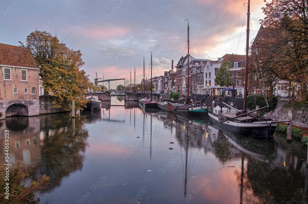 Fototapeta premium Rotterdam, The Netherlands, November 4, 2022: Aelbrechtskolk canal in Delfshaven neighbourhood under a colorful sky at dusk