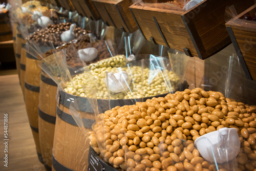 Shop with kegs of sweets and sweets peanuts in chocolate.