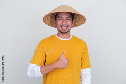 Young Indonesian farmer smiling at camera and give thumb up photo