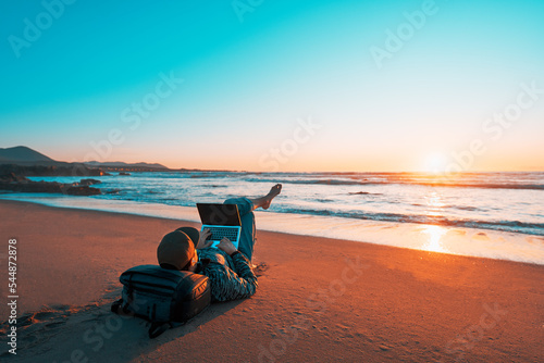 Obraz na plátne mature latin digital nomad laying on the sand of the beach with a laptop working