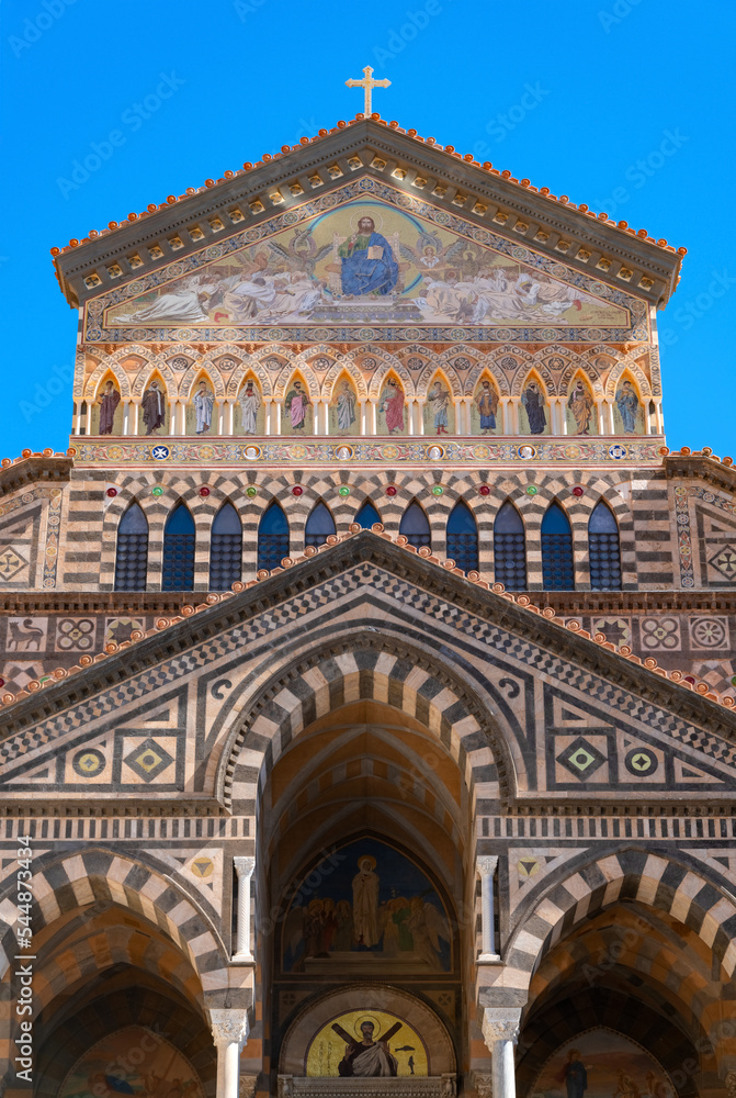 Amalfi Cathedral is a medieval Roman Catholic cathedral at the main square of the mediterranian city in Italy. Colorful entrance facade in historic old town and touristic sight and major monument.