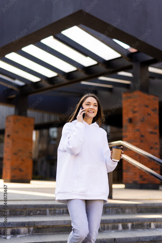 Woman chatting on the phone while taking her coffee Woman chatting on the phone while taking her coffee