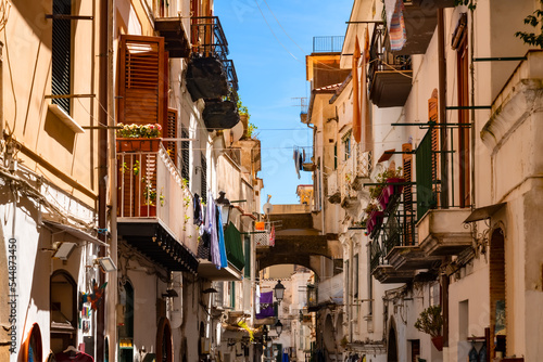 Narrow road “Via Pietro Capuano“ and main street in the old town of Amalfi city in Italy. World heritage destination and popular tourist destination with old facades with balconies, shops and cafes. photo