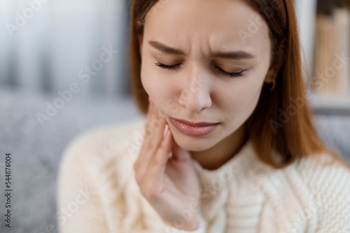 Woman with toothache at home
